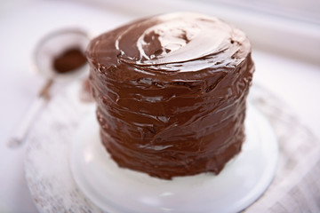 Chocolate cake on a plate on unfocused background