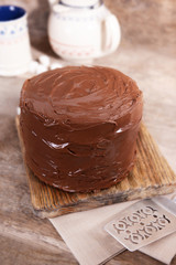 Chocolate cake with blade on a wooden boards background
