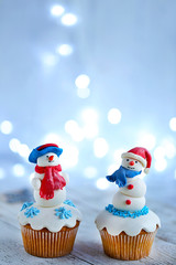Christmas cupcakes with lights on background