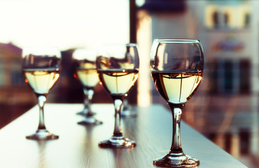 Glasses of wine on light blurred background