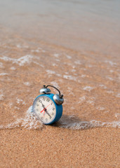 Obraz premium alarm clock on sand beach