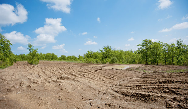 dirty broken rural road with deep tire tracks