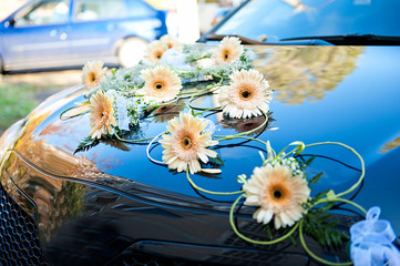 wedding car decorated with flowers on the hood