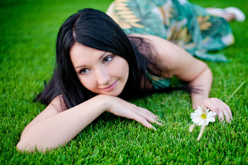 beautiful woman lying on the grass in spring meadow