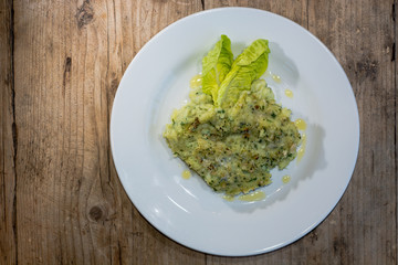 Fish pie from above. Fish pie with potato and herbs served with olive oil and lettuce
