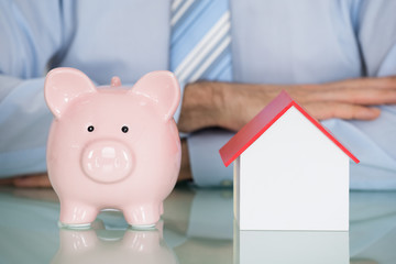 Businessman With Piggyback And Model House