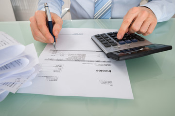Businessman With Invoice And Calculator