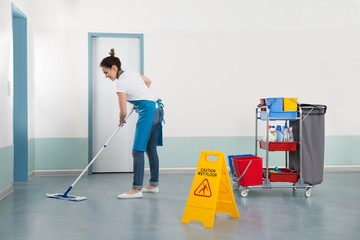 Female Janitor Mopping Corridor