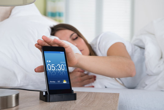 Woman Snoozing Alarm On Mobile Phone Screen