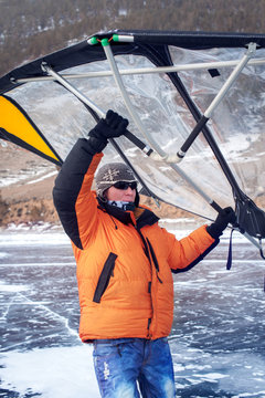 Man standing on ice with wing in the hands.