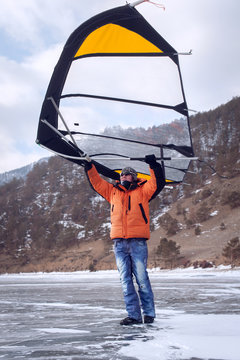 Man standing on ice with wing in the hands.