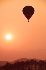 Colorful hot air balloon is flying at sunset. 