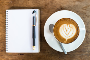 Obraz na płótnie Canvas Coffee cup and notebook on table background.