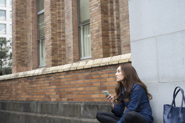 Young woman sitting cross-legged outside