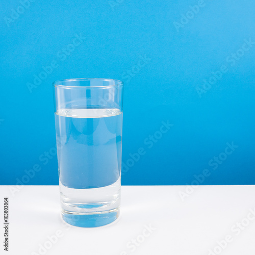"The tall glass of pure mineral water on a white table." Stock photo