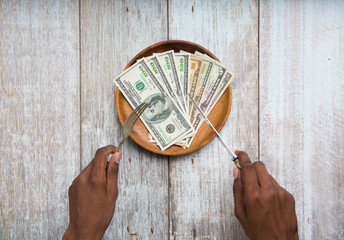  hand eating banknotes symbolising consumerism and corruption