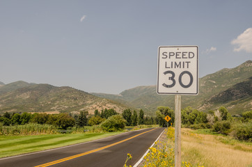 Three Road Signs - Speed Limit 30, Pedestrian Crossing, Sharp Turn