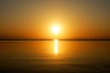 Sunset sky and big sun over the lake.