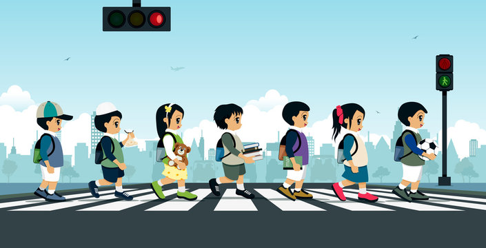 Students walking on a crosswalk with a traffic light.