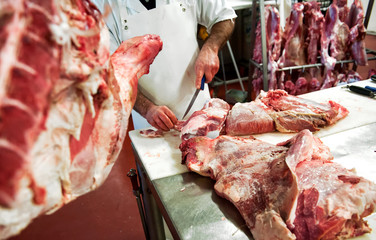 Butcher cutting pieces of meat