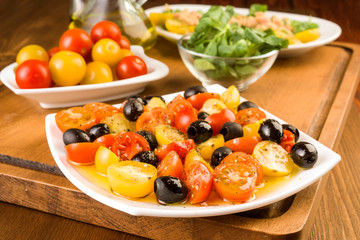 Fototapeta na wymiar salad with cherry tomatoes and olives on wooden