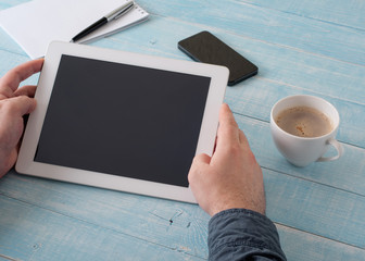 man holding tablet in hand with a blank screen