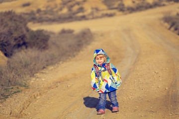 cute little girl with backpack travel on the road