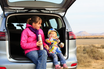 mother and little daughter travel by car in mountains