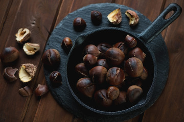 Top view of a frying pan with roasted chestnuts, studio shot