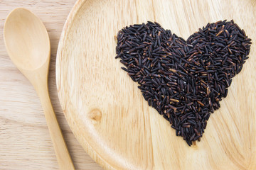 Heart rice berry in wooden bowls with spoon on wooden background. concept