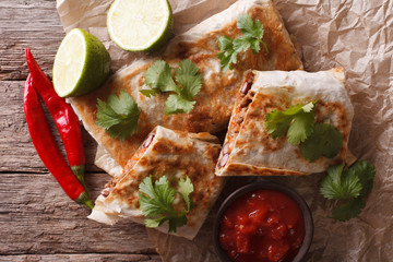 Mexican spicy chimichanga with meat and vegetables. horizontal top view
