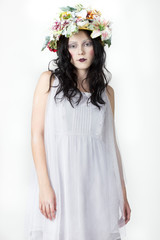 Portrait of Young Woman with Wreath of Flowers on white Background. Beauty Concept. 