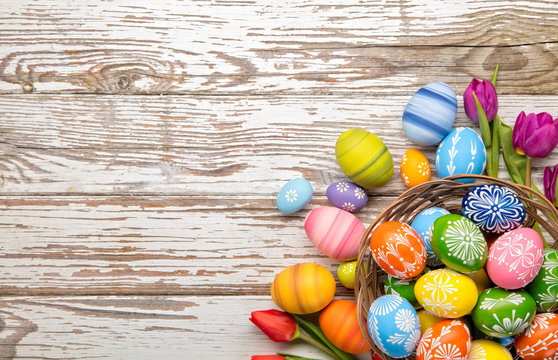 Easter eggs and tulips on wooden planks