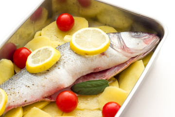 Fish with lemon potatoes and tomatoes ready for the oven