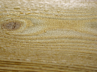 Drops of water on wooden surface.
