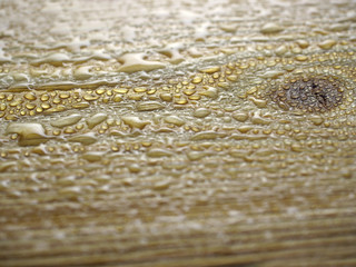 Drops of water on wooden surface.
