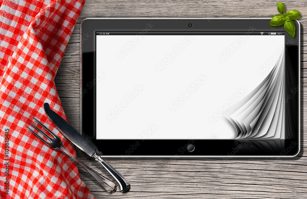 Poster tablet and cutlery on a table with tablecloth / black tablet computer with blank pages on a table in