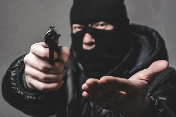 Robber with an aming gun - obrazy, fototapety, plakaty