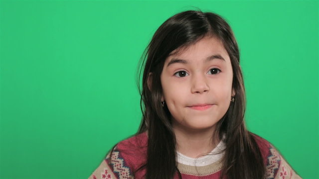 young girl playing with her eyes on green screen