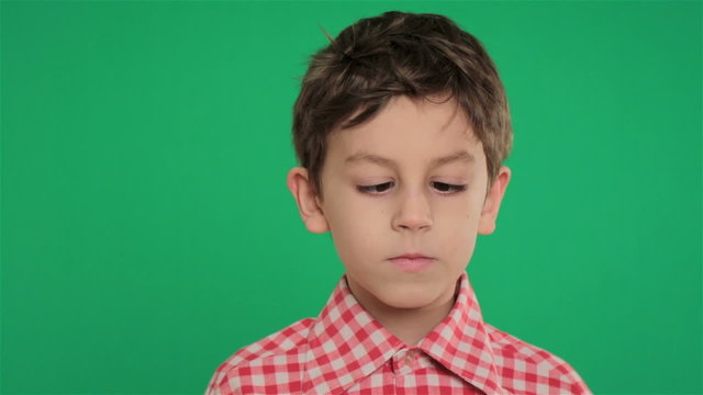 young boy making crossed eyes on green screen