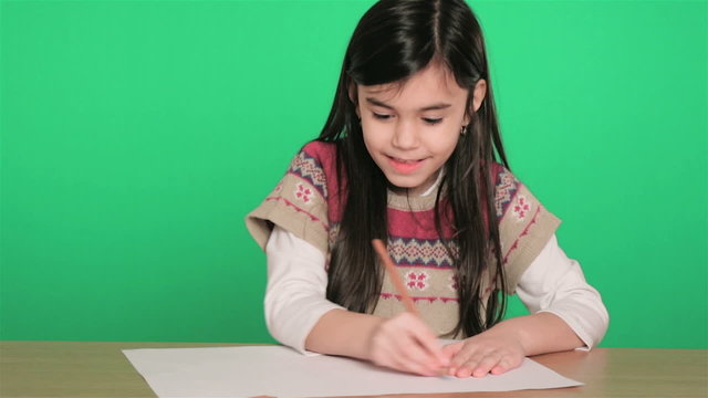 young girl drawing on paper, on green screen