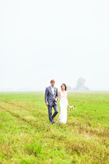 Naklejka premium Young wedding couple walking outdoors