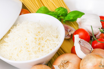 Frisch geriebener Parmesan, italienischer Hartkäse als würzige Zutat für köstliche Nudelgerichte, Spaghetti, frische Tomaten, Basilikum, Knoblauch und Zwiebeln, itallienische Küche, mediterran