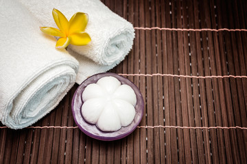 Spa soap mangosteen and towel on bamboo background. soft and fresh towels with flowers - beauty spa.