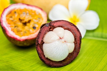 Fresh tropical fruits and flowers on a bamboo background.