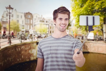 Fototapeta premium Composite image of happy man taking selfie