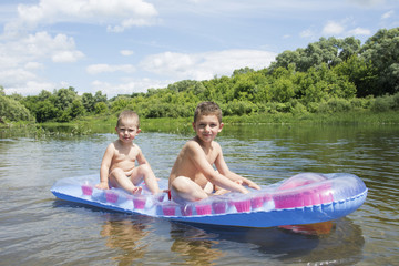 In the summer on the river on an inflatable mattress funny littl