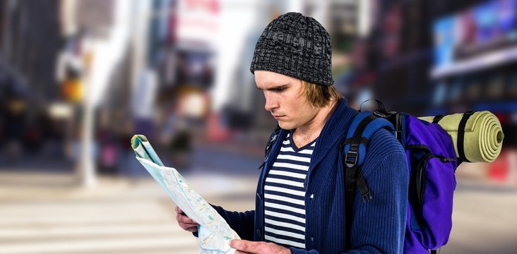 Composite image of backpacker looking a map