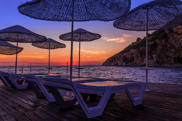 sunbeds and umbrellas at sunset