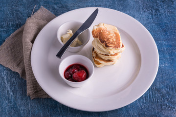 Top view dish with pancakes and knife and butter and strawberry